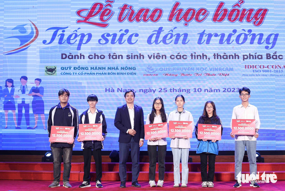 Đại diện nhà tài trợ Hệ thống Anh văn Hội Việt Mỹ (VUS) trao tặng học bổng cho các tân sinh viên - Ảnh: NGUYỄN KHÁNH