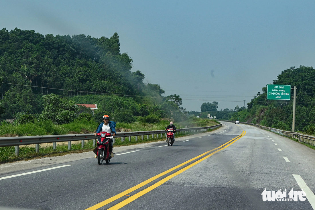 Một số người dân địa phương còn vô tư đi xe máy giữa cao tốc - Ảnh: HỒNG QUANG