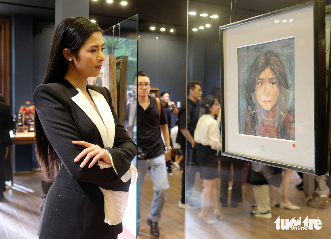 Hoa hậu Ngọc Hân bên những bức tranh của họa sĩ Bùi Văn Tuất - Ảnh: M.V