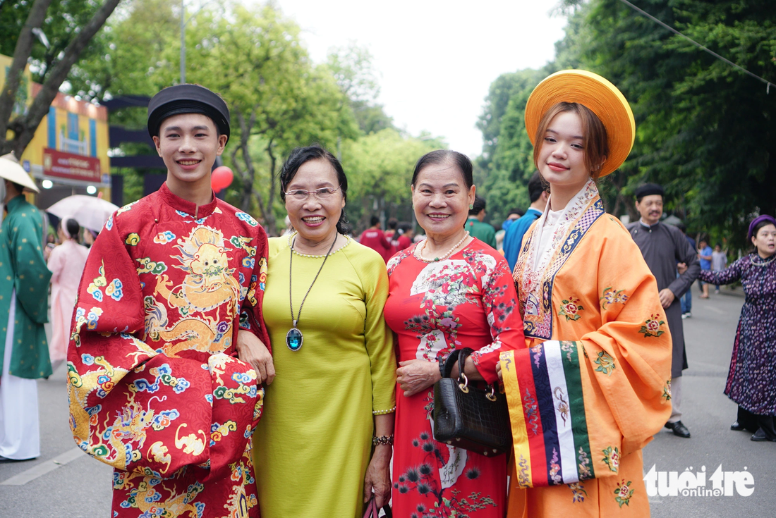 Bà Phạm Thị Hiền (áo dài vàng) cho rằng việc các bạn trẻ thực hiện các sự kiện như Bách hoa bộ hành rất có ý nghĩa - Ảnh: NGUYỄN HIỀN