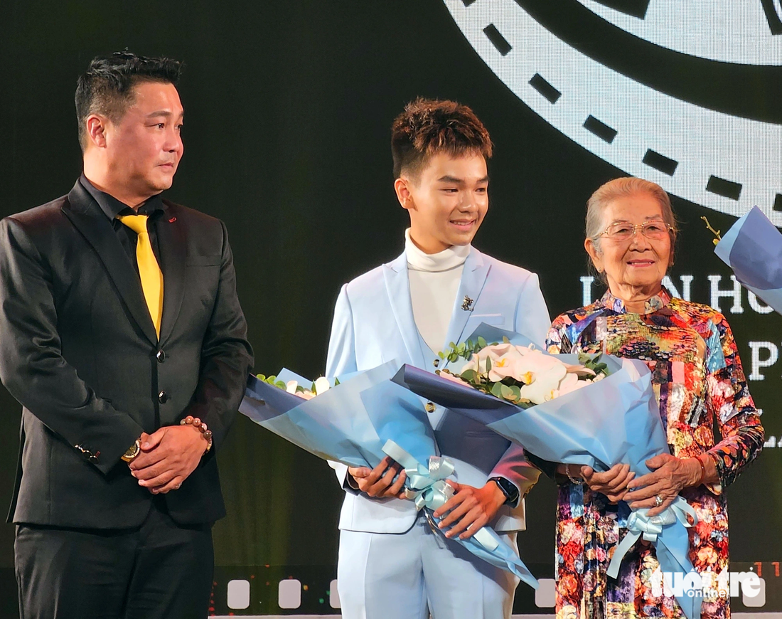 Nghệ sĩ Phi Điểu cùng diễn viên Huỳnh Hữu Khang nhận giải diễn xuất tại Liên hoan phim ngắn TP.HCM. Người trao giải là diễn viên Lý Hùng - Ảnh: MI LY