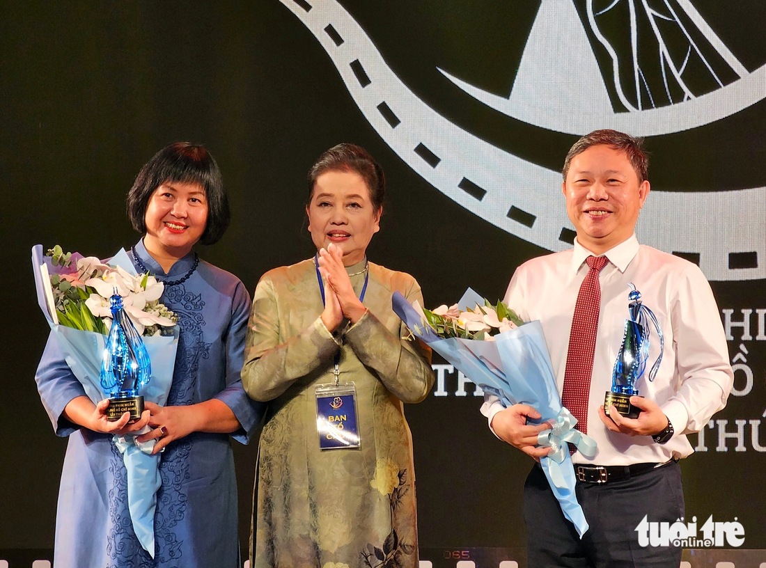 Bà Dương Cẩm Thúy (giữa), trưởng ban tổ chức liên hoan phim, tặng món quà đặc biệt là chiếc cúp kỷ niệm cho ông Dương Anh Đức, phó chủ tịch UBND TP.HCM và bà Nguyễn Thị Thu Hà, phó cục trưởng Cục Điện ảnh, vì những đóng góp lớn cho liên hoan phim - Ảnh: MI LY