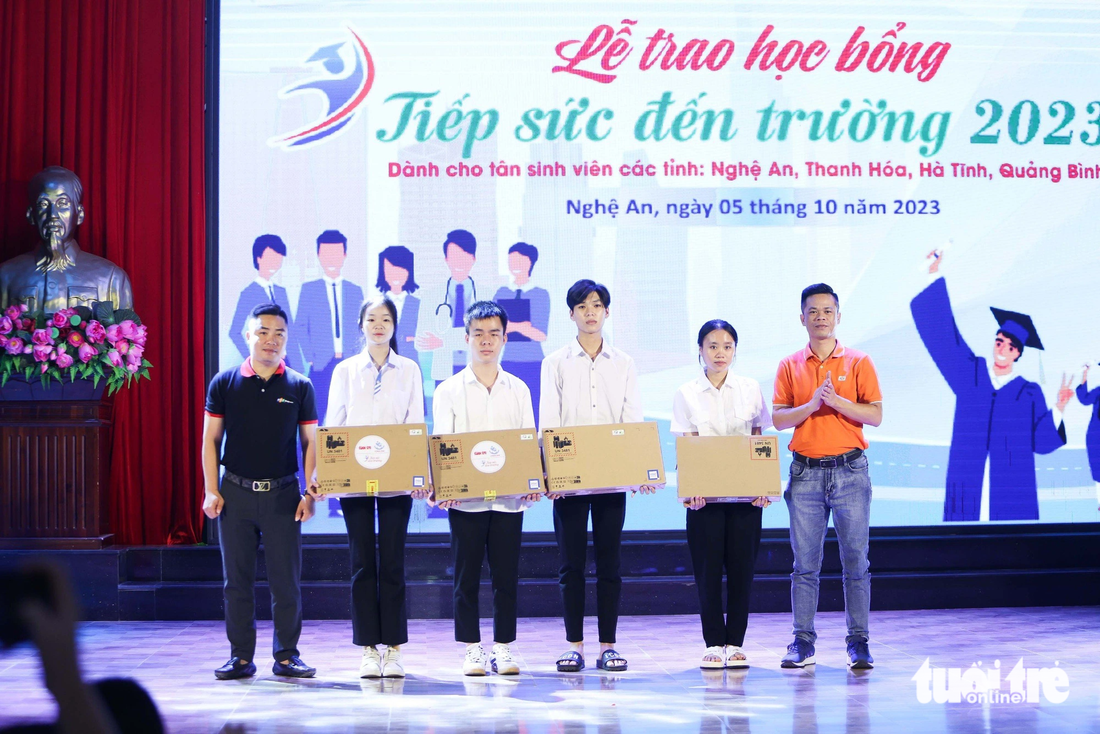 Đại diện nhà tài trợ FPT Shop và quỹ khuyến học Vinacam trao tặng 4 laptop cho các tân sinh viên - Ảnh: NGUYỄN KHÁNH 