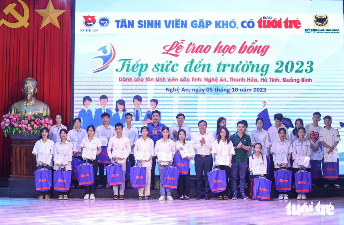 Các đại biểu chụp ảnh lưu niệm với các tân sinh viên tỉnh Nghệ An nhận học bổng Tiếp sức đến trường - Ảnh: NGUYỄN KHÁNH