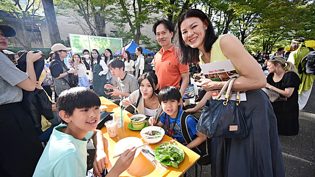 Gia đình anh Lân, chị Đoan và 3 con sống tại Nhật Bản 25 năm thưởng thức phở tại lễ hội - Ảnh: QUANG ĐỊNH