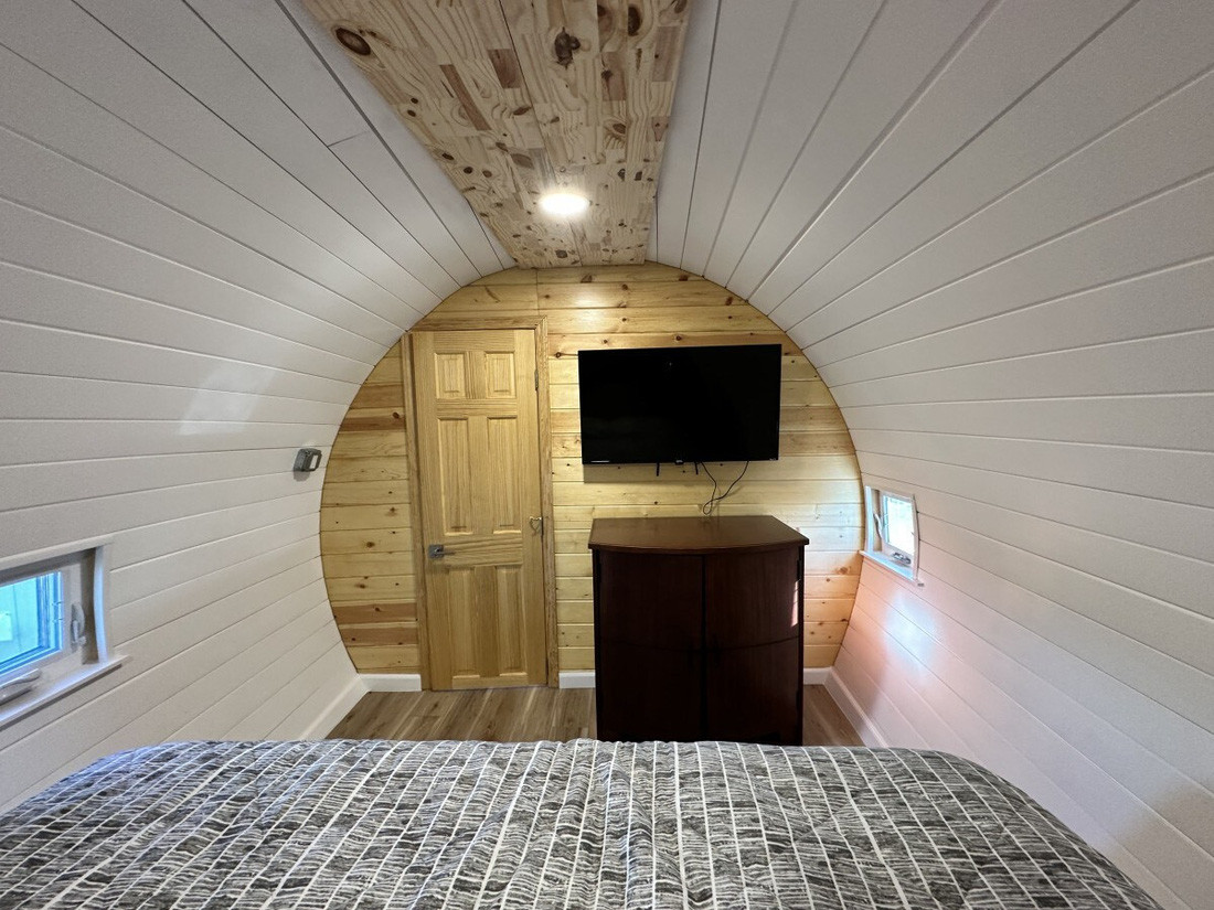 Tiếp theo là phòng ngủ chính với giường cỡ King. Căn phòng vẫn giữ được đường cong tự nhiên của máy bay, trong khi được bổ sung nét hiện đại như TV màn hình phẳng - Ảnh: Airbnb