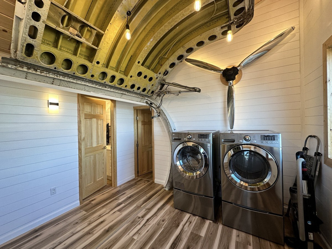 Bước qua cửa máy bay là không gian tiền sảnh với máy giặt - Ảnh: Airbnb