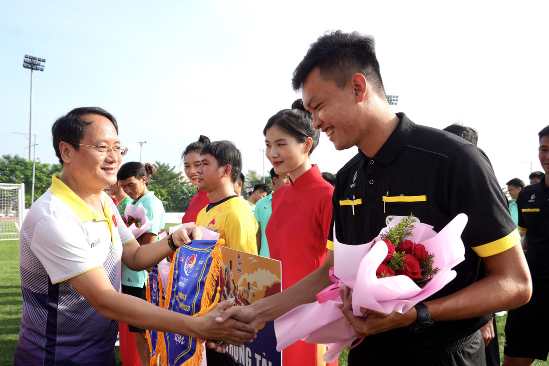 Ông Nguyễn Hoàng Nguyên - phó tổng biên tập báo Tuổi Trẻ - trao cờ lưu niệm cho đại diện tổ trọng tài và các đội bóng - Ảnh: HỮU HẠNH