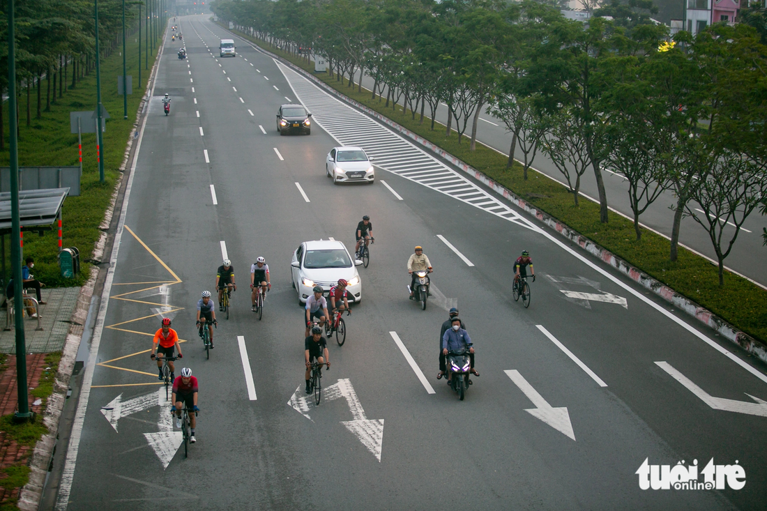 Một tốp người đi xe đạp dàn ngang &quot;bao vây&quot; một xe ô tô ở làn dành cho ô tô trên đường Phạm Văn Đồng, TP Thủ Đức, TP.HCM
