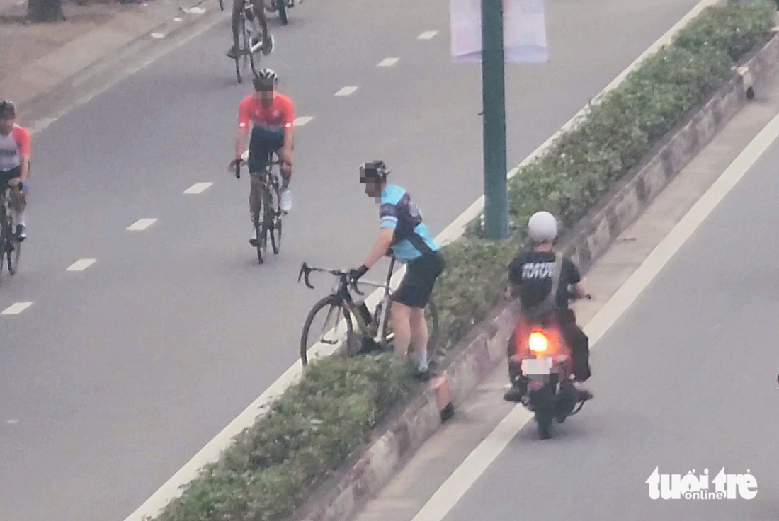 Ảnh chụp gần 6h sáng 8-10 trên đường Phạm Văn Đồng, quận Bình Thạnh, cho thấy khi biết lực lượng chức năng đang ở phía trước, một người đi xe đạp khiêng xe qua dải phân cách vào làn trong