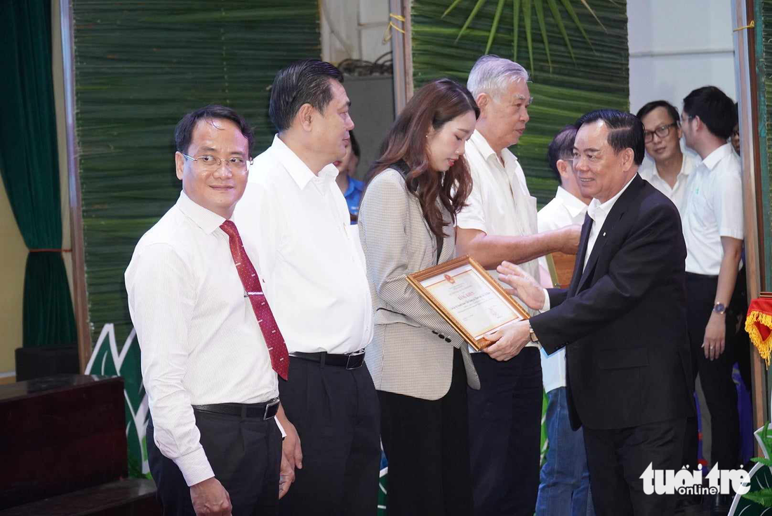 Ông Trần Ngọc Tam - chủ tịch UBND tỉnh Bến Tre - tặng bằng khen ghi nhận những đóng góp của đơn vị tổ chức, các nhà tài trợ đã nhiều năm liền đồng hành với chương trình cho báo Tuổi Trẻ và các nhà tài trợ - Ảnh: MẬU TRƯỜNG