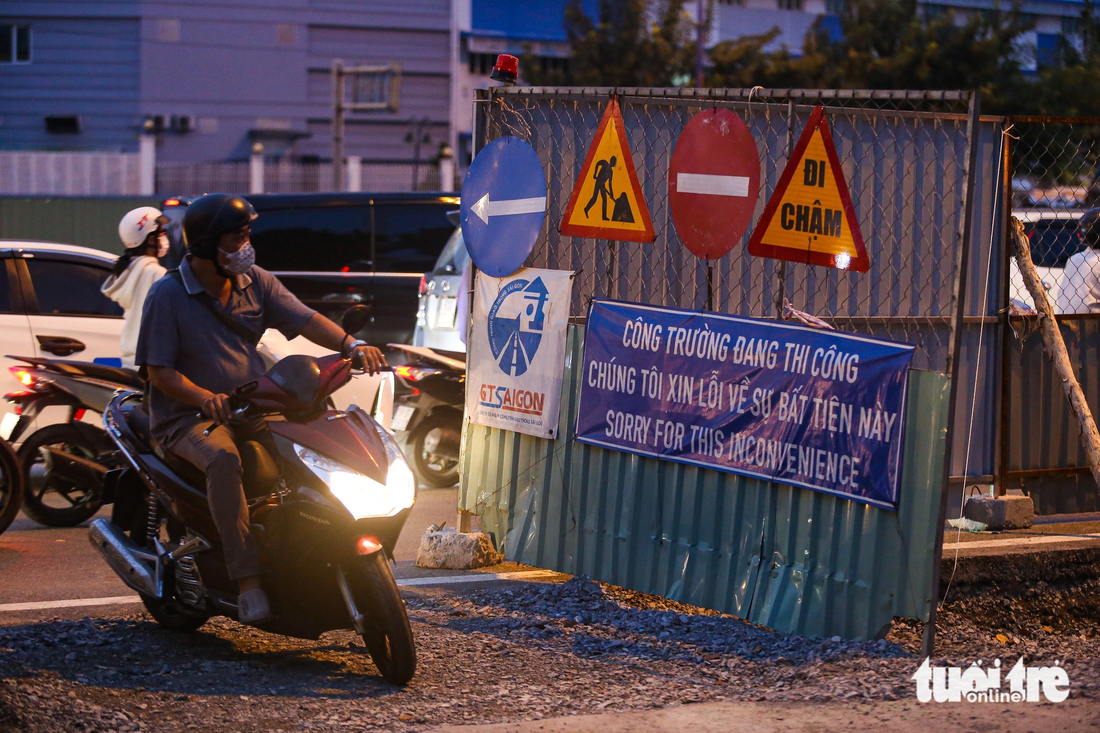 Hàng trăm người đi xe máy phải chạy vòng qua rào chắn, luồn lên vỉa hè để qua đoạn kẹt xe tại nút giao An Phú.