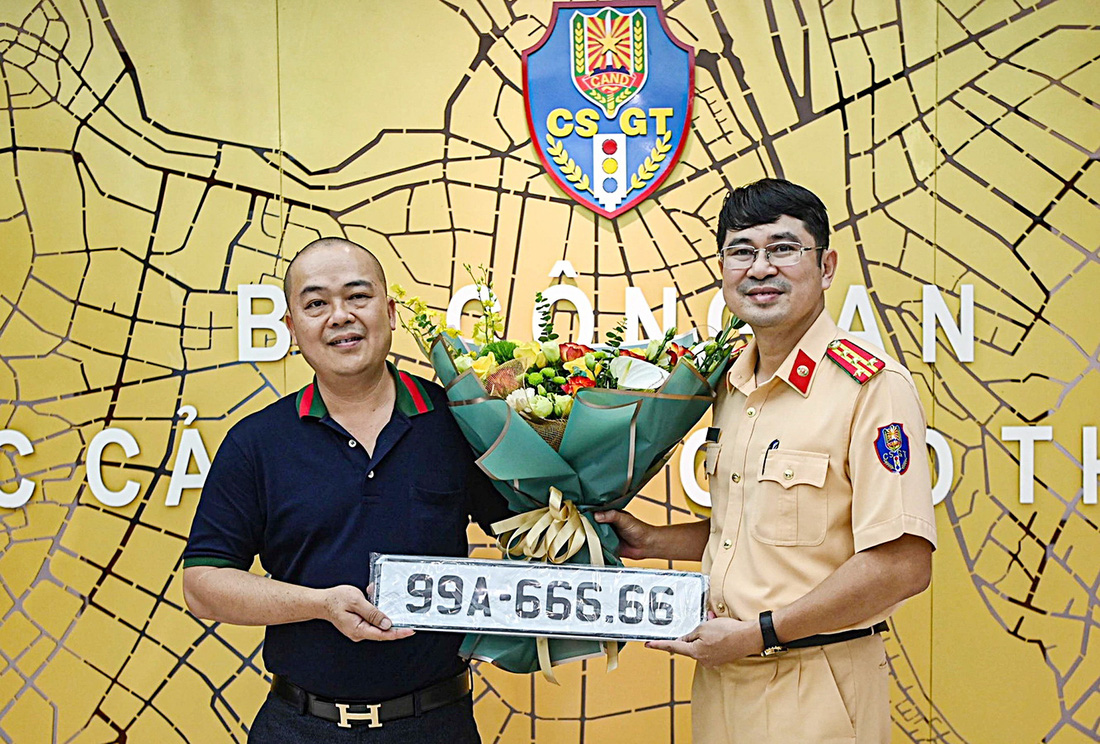 Đại diện Cục Cảnh sát giao thông trao biển số trúng đấu giá cho khách hàng Nguyễn Thạc Đức - Ảnh: HỒNG QUANG