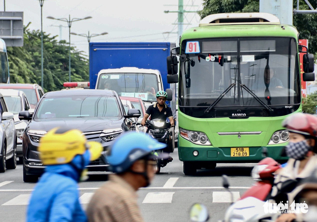 Xe máy luồn lách trong làn ô tô chạy trên đường Phạm Văn Đồng - Ảnh: TIẾN QUỐC