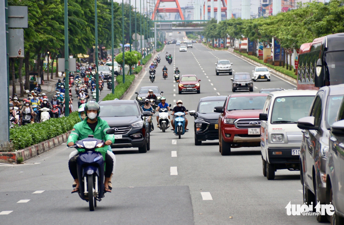 Nhiều người bất chấp nguy hiểm chạy vào làn ô tô đường Phạm Văn Đồng - Ảnh: TIẾN QUỐC