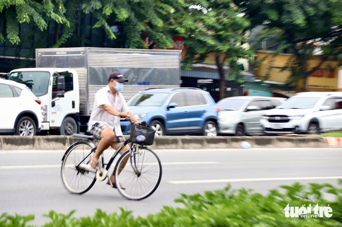 Người đi xe đạp thì sẵn sàng vác xe, băng ngang qua đường, đỡ phải vòng qua các giao lộ ở xa - Ảnh: TIẾN QUỐC