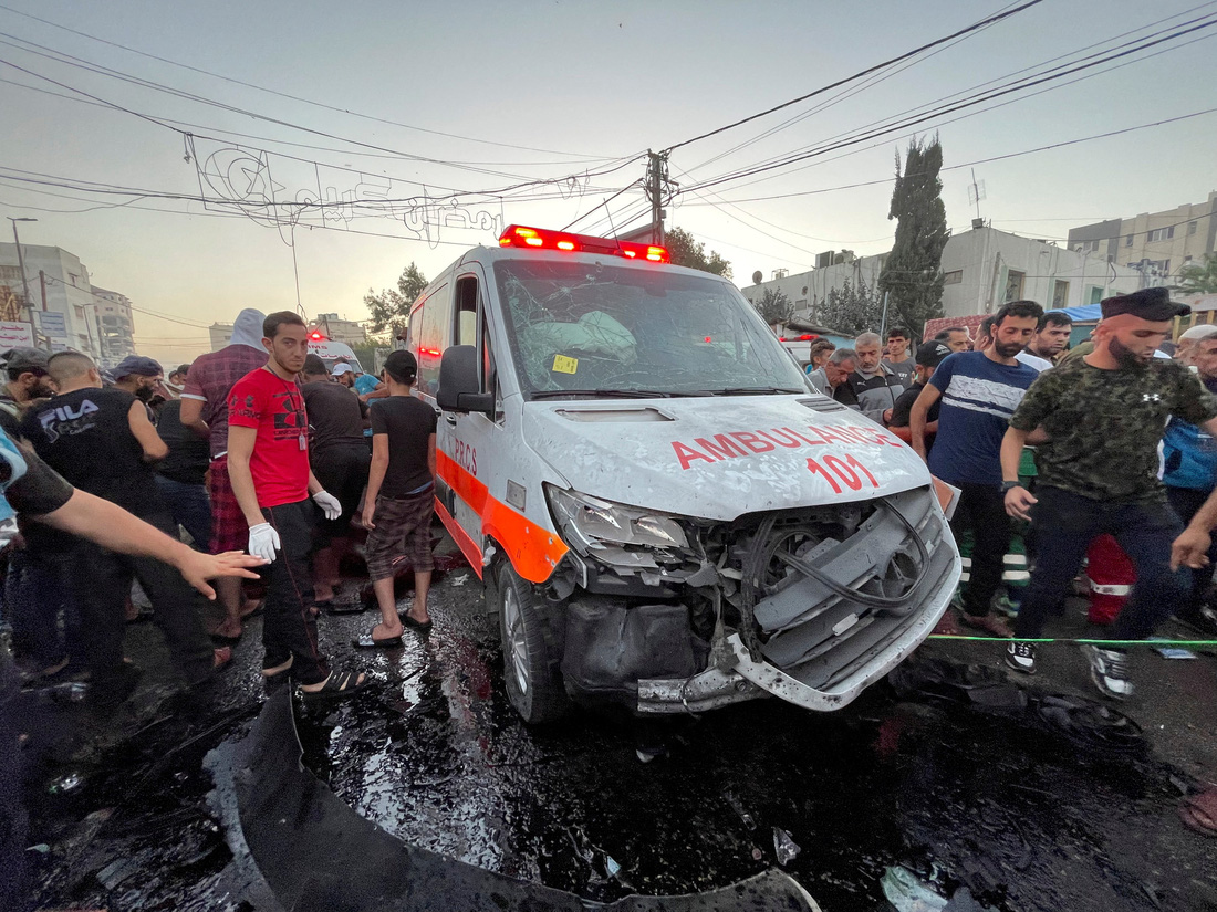 Người dân Gaza kiểm tra một xe cứu thương bị hư hại do không kích của Israel vào cổng Bệnh viện Al Shifa hôm 3-11. Nhiều tuần qua, IDF liên tục khẳng định Hamas đang trốn tại đây và tấn công các khu vực xung quanh bệnh viện - Ảnh: AFP