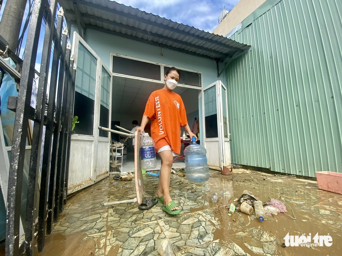 Người dân đường Mẹ Suốt dọn dẹp sau khi nước tràn về nhà. Đây là khu vực bị ngập mỗi khi kênh Phú Lộc không thoát nước kịp ra biển - Ảnh: TRƯỜNG TRUNG