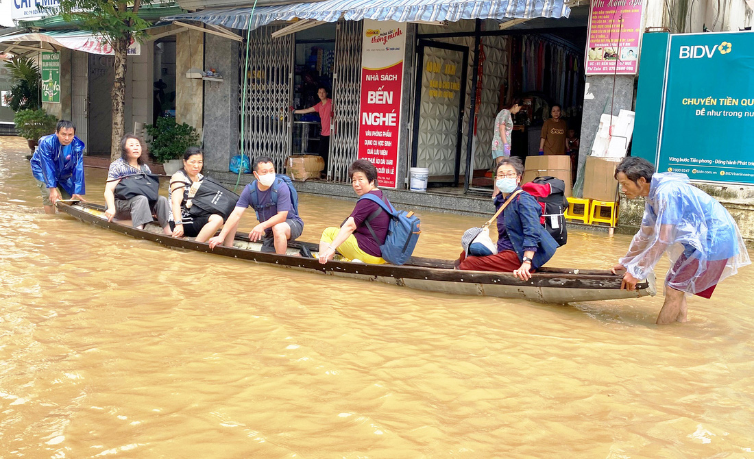 Dùng ghe thuyền chở du khách ra khỏi vùng ngập sâu ở trung tâm thành phố  - Ảnh: LÊ TRUNG