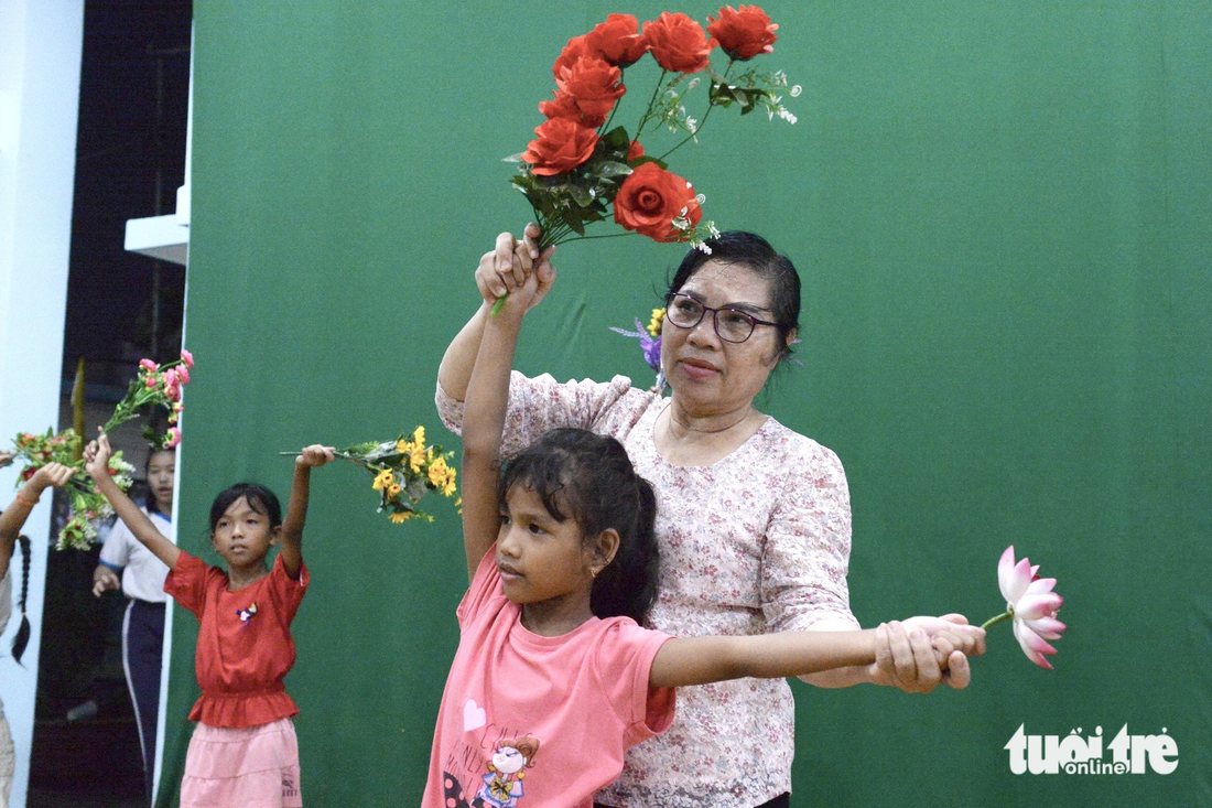 Cô Bảy lo việc hậu cần nấu ăn kiêm đạo diễn hướng dẫn các bé tập múa hoa - Ảnh: HẢI QUỲNH