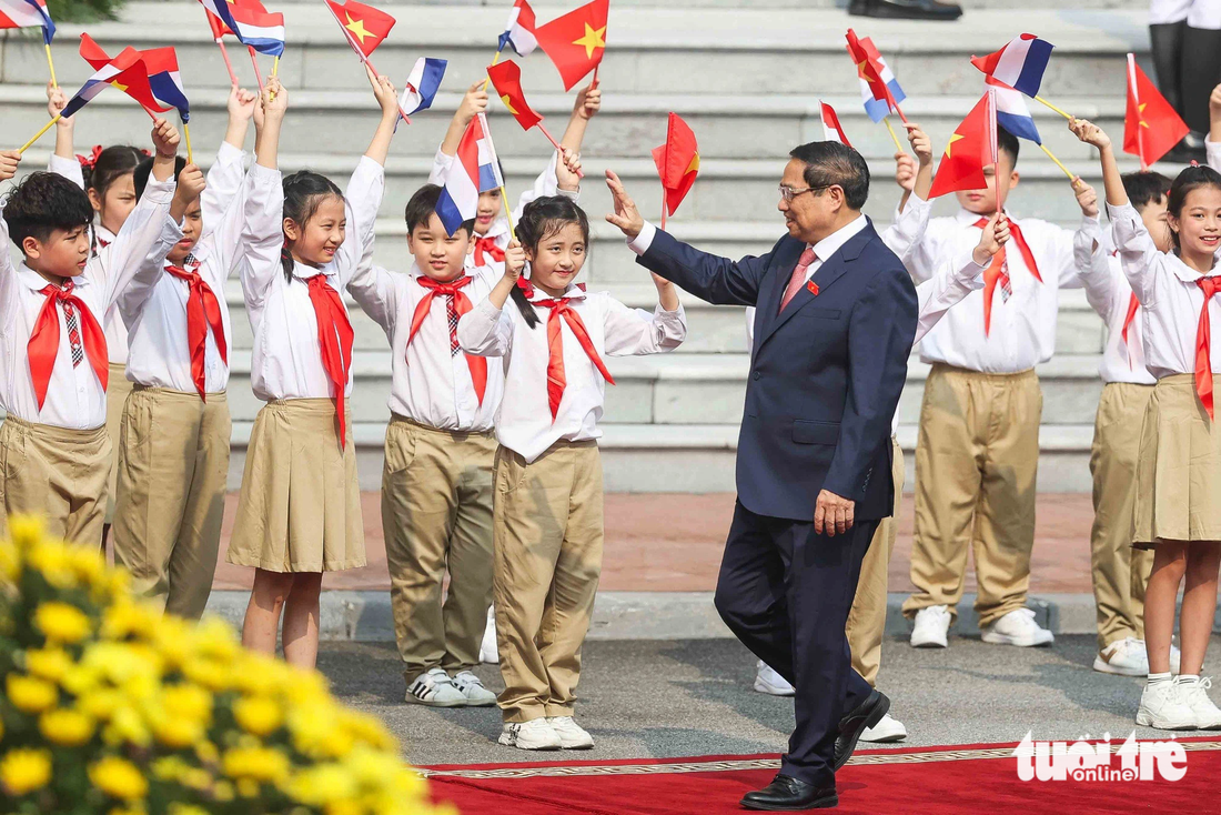 Thủ tướng Phạm Minh Chính vẫy tay chào các em thiếu nhi Hà Nội khi đón Thủ tướng Hà Lan Mark Rutte - Ảnh: NGUYỄN KHÁNH