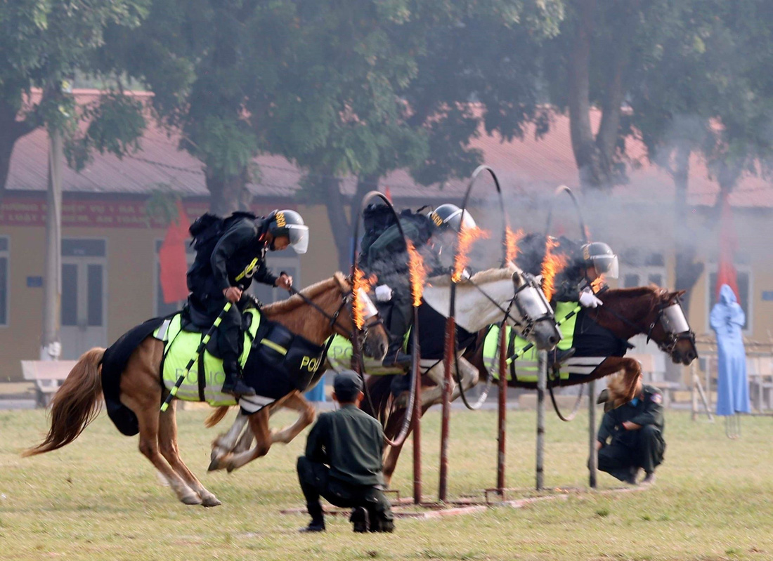 Các chiến sĩ cảnh sát cơ động kỵ binh biểu diễn nhảy qua vòng lửa - Ảnh: TTXVN