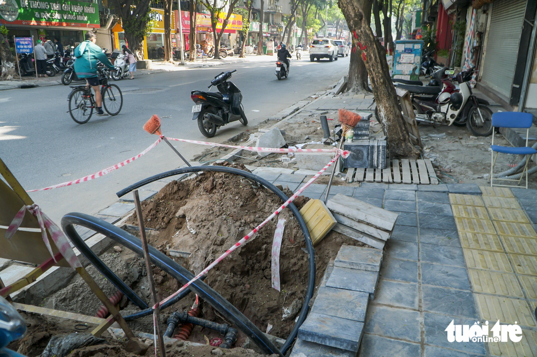 Vỉa hè bị đào xới như những &quot;đại công trường&quot;, ảnh hưởng tới việc đi lại, kinh doanh của người dân - Ảnh: PHẠM TUẤN