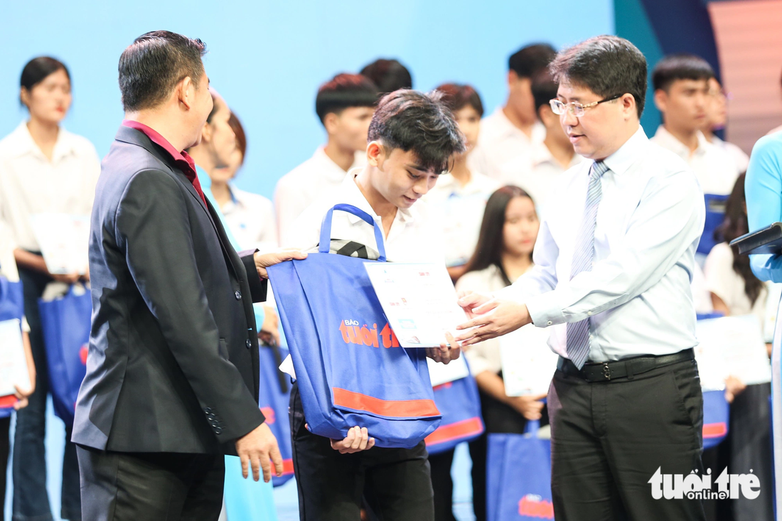 Ông Phạm Hồng Sơn (bên phải) - chánh Văn phòng Thành ủy TP.HCM - trao học bổng cho tân sinh viên - Ảnh: PHƯƠNG QUYÊN