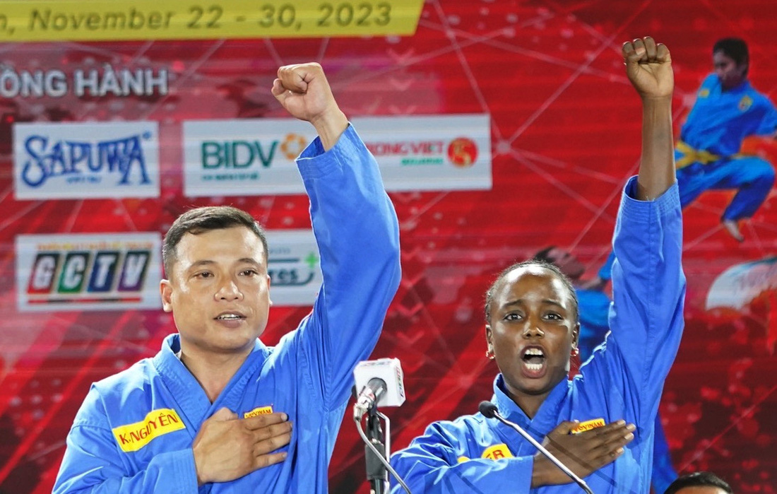 Vận động viên Huỳnh Khắc Nguyên (đội tuyển vovinam Việt Nam) và Alkherraz Hadjer (đội tuyển vovinam Algeria) đại diện vận động viên đọc lời tuyên thệ - Ảnh: QUANG THỊNH