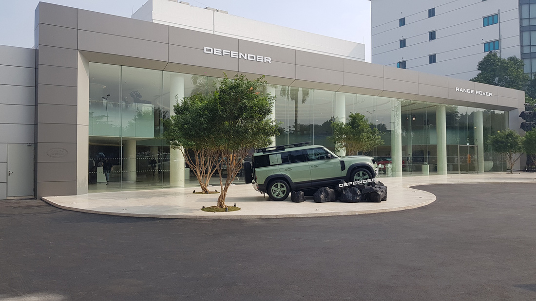 JLR tách riêng 2 tên dòng xe Defender và Range Rover ở 2 bên showroom. Điều này giúp khách hàng dễ định hướng tới chiếc xe mình cần xem trước khi bước vào bên trong. Sau khi bước qua cửa kính, khách hàng sẽ được nhân viên hướng dẫn để trải nghiệm không gian trưng bày xe ở phía trong - Ảnh: JLR