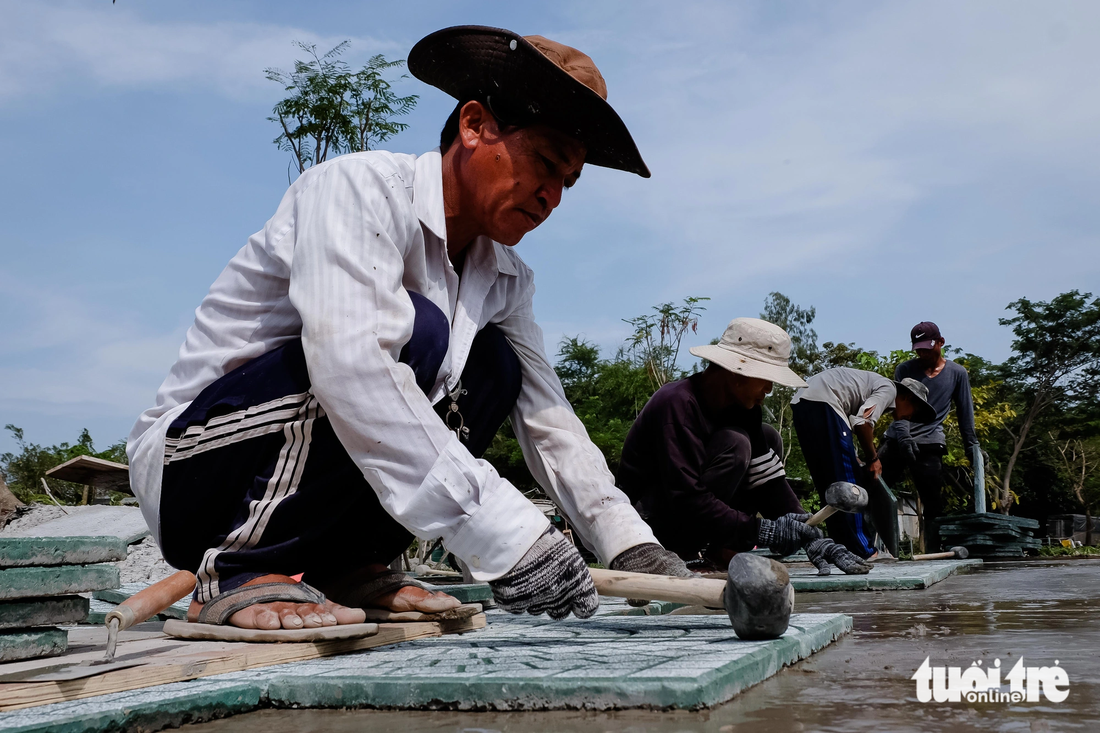 Trưa 29-11, công nhân đang lát gạch nền đường, sẽ hoàn thiện và bàn giao cho chủ đầu tư công viên vào sáng mai - Ảnh: PHƯƠNG NHI