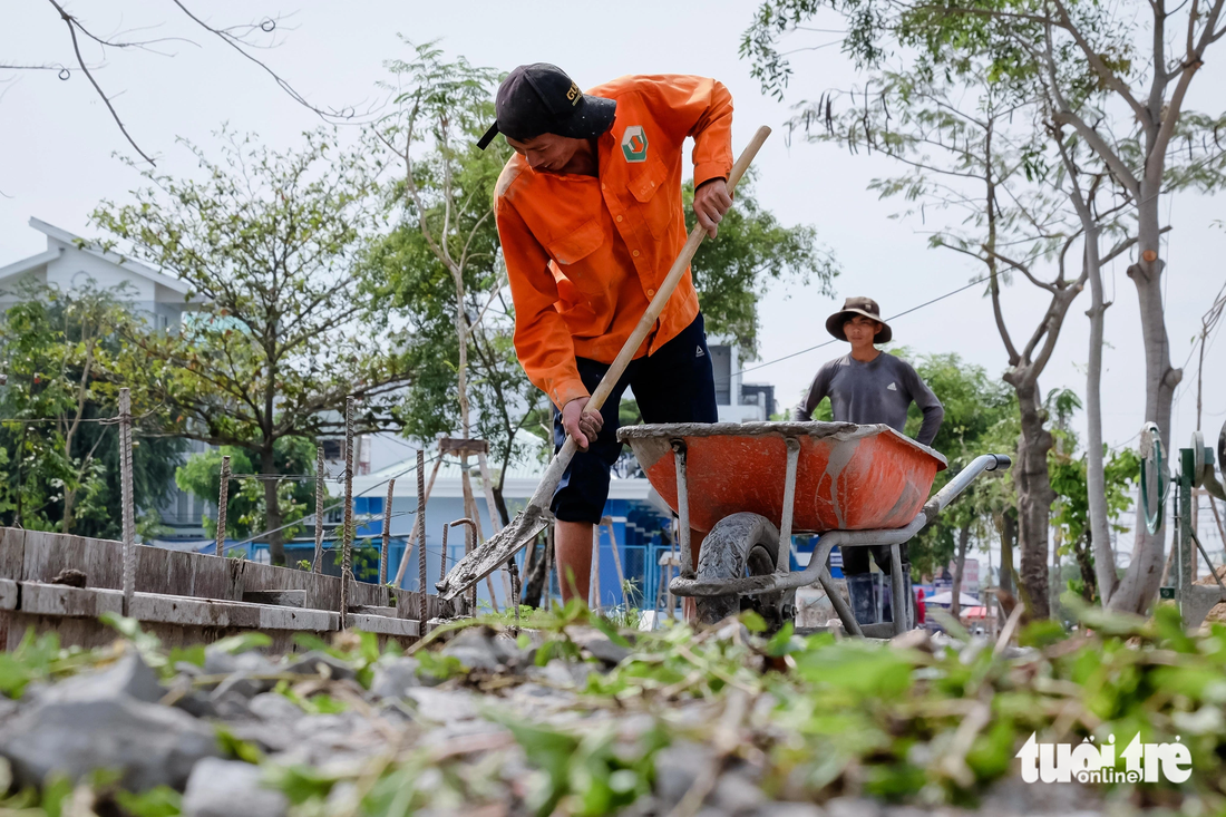 Công nhân đang thi công hoàn thiện phần vỉa hè công viên phía đường Bình Thành - Ảnh: PHƯƠNG NHI