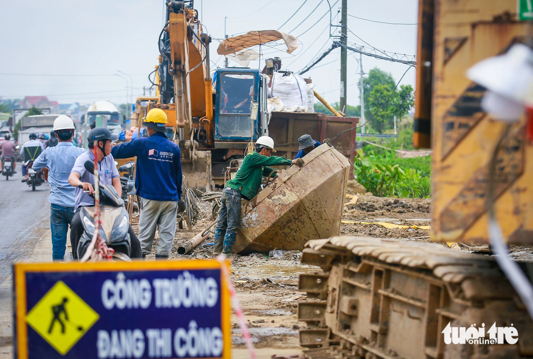 Trước khó khăn nêu trên, Ban Giao thông kiến nghị UBND TP.HCM làm việc với UBND các tỉnh có nguồn vật liệu cát san lấp hỗ trợ cung cấp cho dự án đường vành đai 3. Trong ảnh là các công nhân đang vệ sinh phễu để đổ bê tông, cát - Ảnh: CHÂU TUẤN