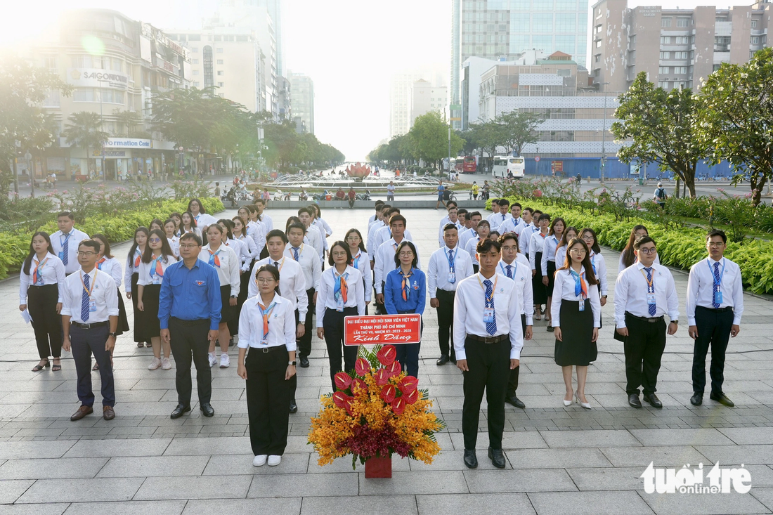Đoàn đại biểu thay mặt đại hội đâng hoa báo công tại tượng đài Chủ tịch Hồ Chí Minh tại phố đi bộ Nguyễn Huệ (quận 1, TP.HCM) - Ảnh: HỮU HẠNH
