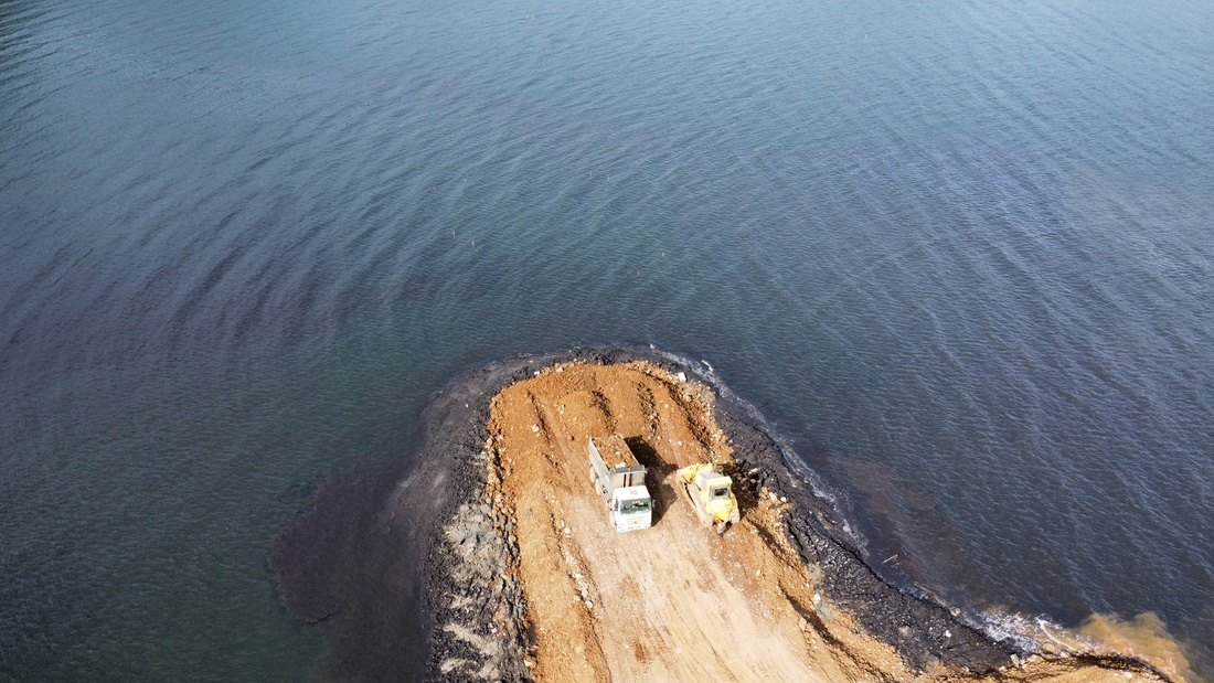 Xe tải chở đất đá lấp vịnh biển gây ảnh hưởng không nhỏ đến môi trường vịnh - Ảnh: L.DŨNG
