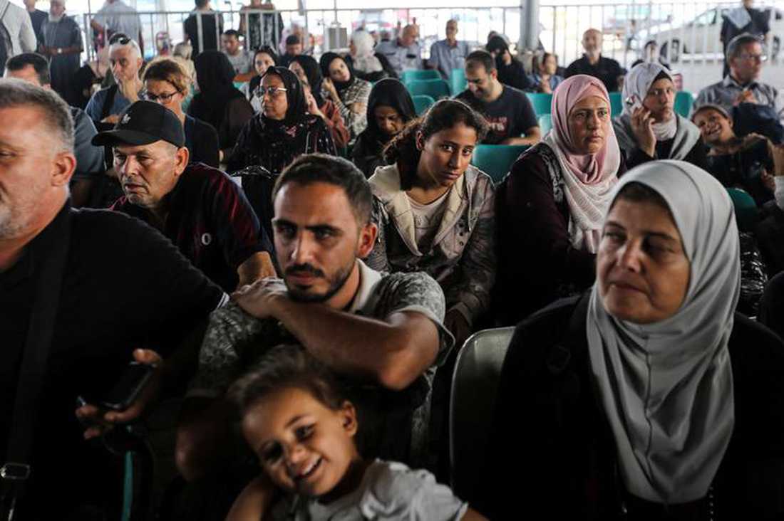 Ngày 2-11, nhóm người có hộ chiếu nước ngoài chờ đợi ở cửa khẩu Rafah của Ai Cập để rời khỏi Gaza. Kể từ đầu tháng 11, thông qua thỏa thuận do Qatar làm trung gian, những người bị thương nặng và người nước ngoài đã được phép rời khỏi Dải Gaza để đến Ai Cập - Ảnh: THE HINDU/GETTY IMAGES