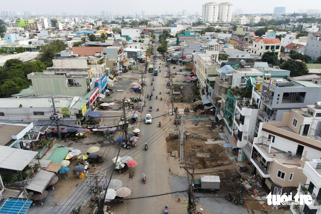 Trên tỉnh lộ 10, hàng loạt nhà dân đã lùi sâu vào trong nhường chỗ cho dự án cầu Bà Hom. Tuy nhiên theo ghi nhận của Tuổi Trẻ Online, nhiều trụ điện vẫn chưa được di dời - Ảnh: PHƯƠNG NHI