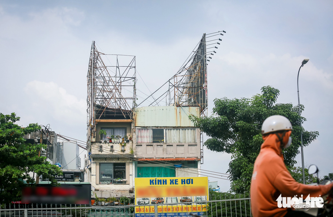 Người dân phản ánh hai khung sắt hoen gỉ, cong vênh của bảng quảng cáo trên nóc một ngôi nhà ở đường Điện Biên Phủ (quận Bình Thạnh) làm họ bất an khi đi ngang qua - Ảnh: CHÂU TUẤN