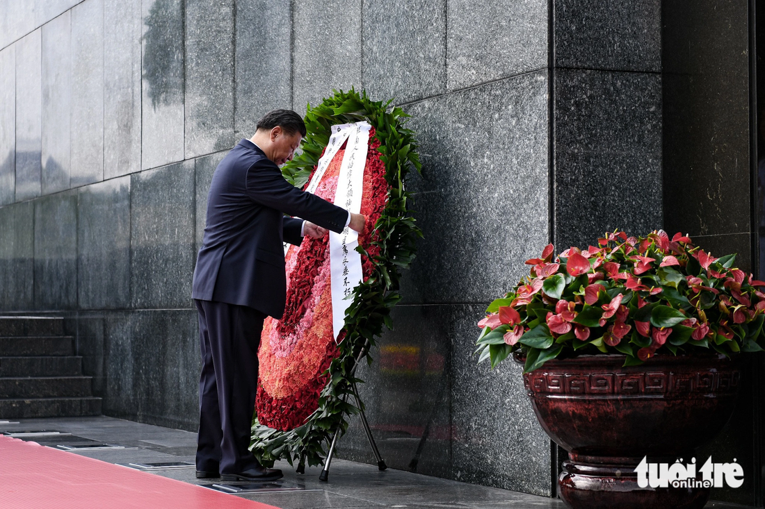 Tổng bí thư, Chủ tịch nước Trung Quốc Tập Cận Bình chỉnh dòng chữ trên vòng hoa - Ảnh: NAM TRẦN