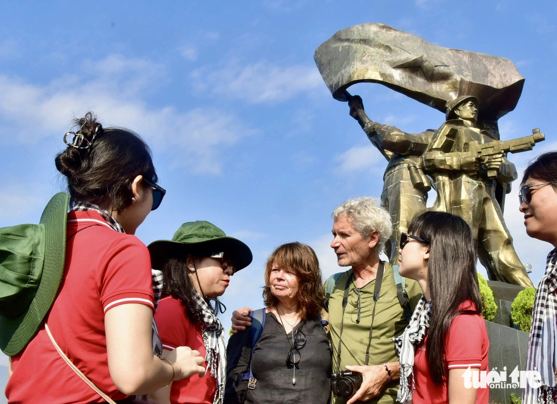 Vợ chồng ông Serge và vợ Agnes (du khách người Pháp) chào hỏi các thành viên của đoàn khi mọi người tham quan tượng đài Chiến thắng Điện Biên Phủ - Ảnh: T.T.D.