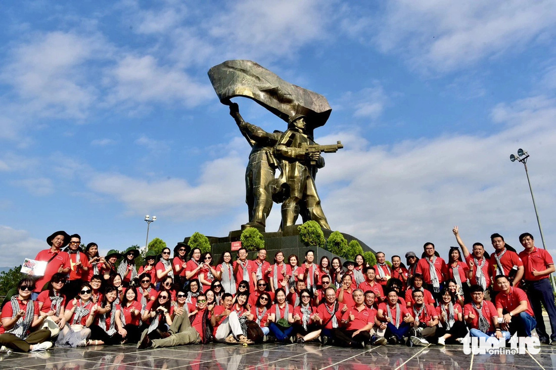 Các thành viên trong đoàn chụp ảnh lưu niệm dưới tượng đài Chiến thắng Điện Biên Phủ - Ảnh: T.T.D.