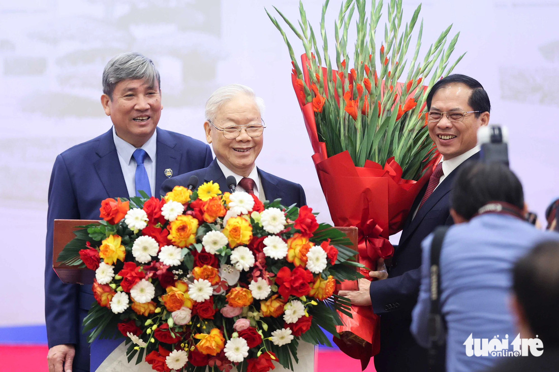 Bộ trưởng Bộ Ngoại giao Bùi Thanh Sơn tặng hoa cho Tổng bí thư Nguyễn Phú Trọng - Ảnh: NGUYỄN KHÁNH