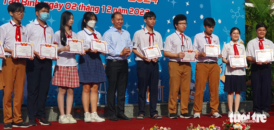 Tại ngày hội STEM, ông Phan Văn Quang, trưởng Phòng Giáo dục và Đào tạo quận Tân Bình, trao thưởng cho các học sinh đạt giải nghiên cứu khoa học cấp quận - Ảnh: HOÀNG HƯƠNG