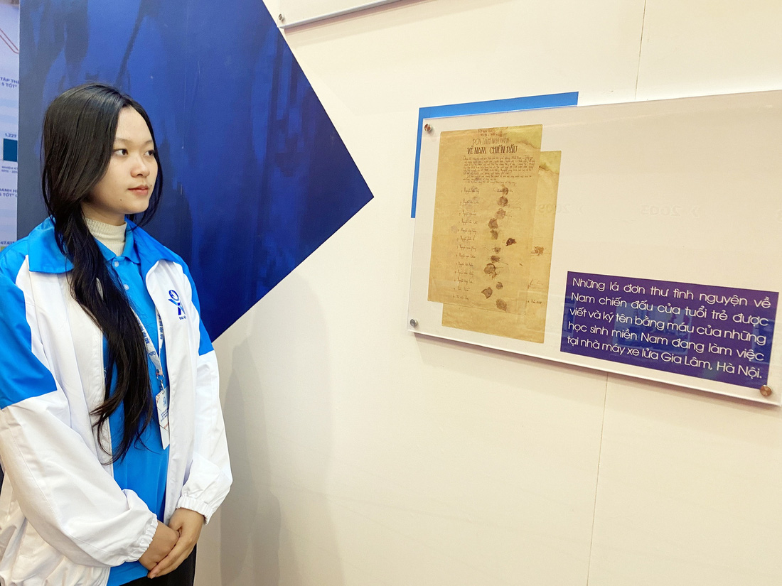 Đại biểu đọc đơn tình nguyện về Nam chiến đấu được triển lãm tại đại hội - Ảnh: H.THANH