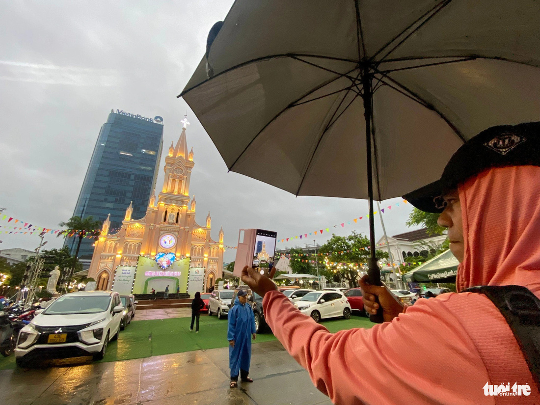 Du khách nước ngoài chụp ảnh trước nhà thờ Chánh tòa Đà Nẵng - Ảnh: TRƯỜNG TRUNG