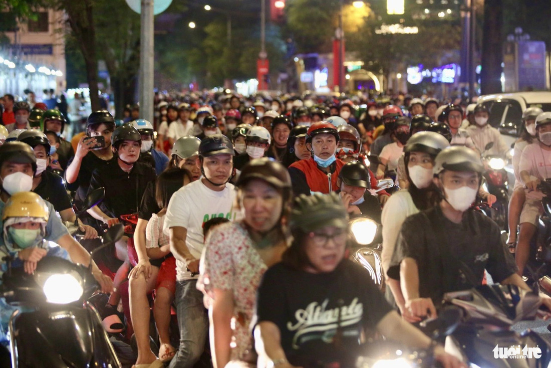 At 8:00 p.m., on Dong Khoi Street toward the center of District 1, motorbikes inched behind each other.  People drove their motorbikes to the sidewalk to get around.
