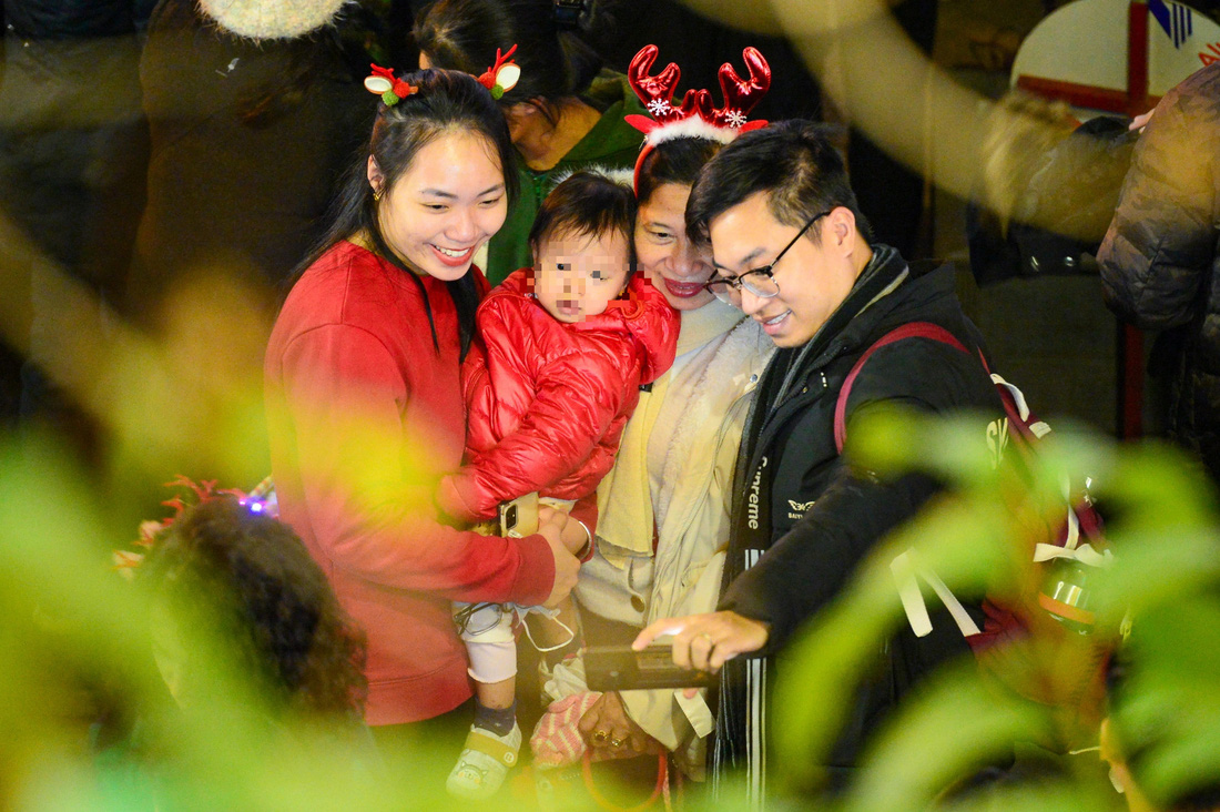 Nhiều gia đình chuẩn bị đầy đủ quần áo ấm để đưa trẻ nhỏ vui Giáng sinh trong tiết trời se lạnh của Hà Nội - Ảnh: HÀ QUÂN