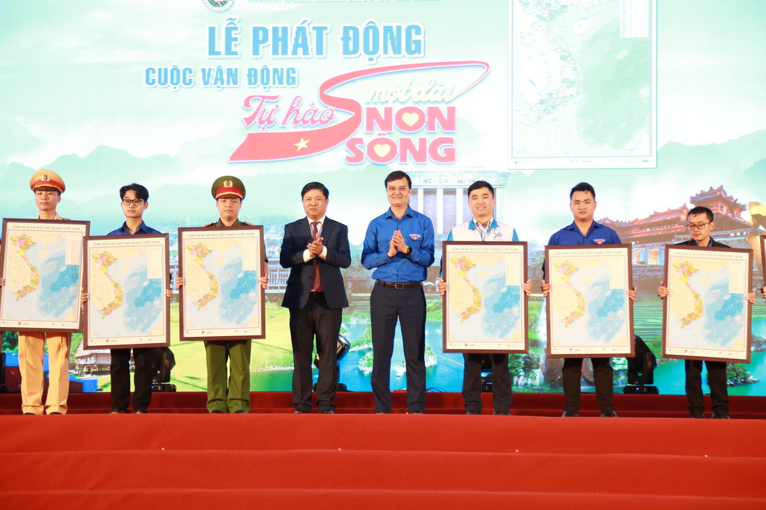 Anh Bùi Quang Huy và ông Lương Nguyễn Minh Triết (giữa) trao tặng 20 bản đồ khung (A1) cho 20 cá nhân là đại diện các lực lượng ngư dân, bộ đội biên phòng, thanh niên công nhân, giáo viên, dân tộc, tôn giáo... - Ảnh: ĐOÀN NHẠN