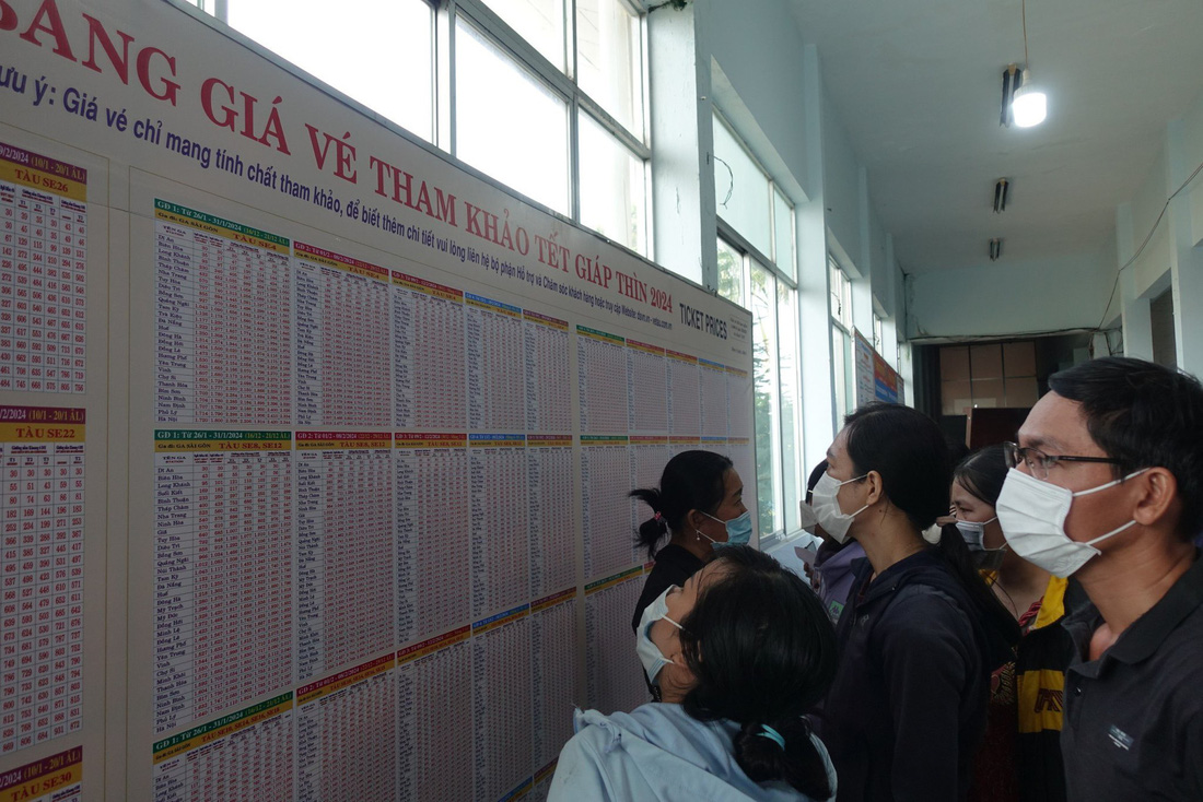 Người dân xem giá vé tàu Tết tại ga Sài Gòn - Ảnh: PHƯƠNG NHI
