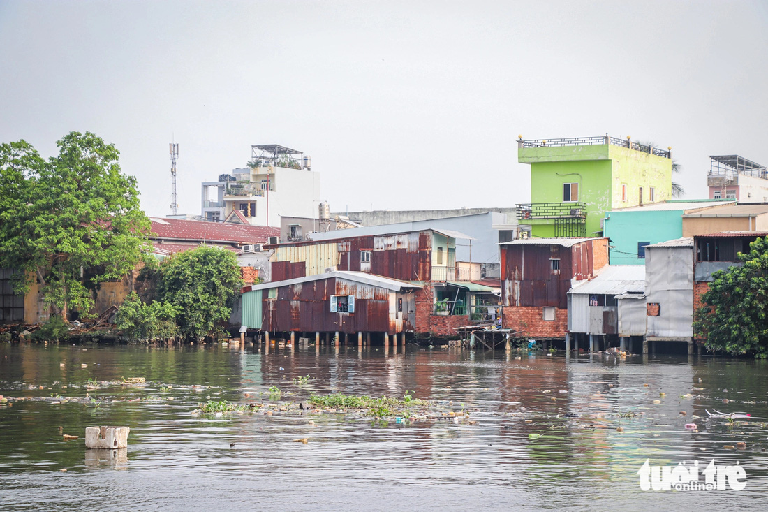 Nhà dựng tạm bợ bằng tôn, chống cọc gỗ và rác rến bủa vây là thực trạng đang xảy ra tại kênh Đôi (quận 8, TP.HCM) - Ảnh: CHÂU TUẤN